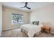 Cozy bedroom featuring a comfortable bed, soft carpet, a ceiling fan and a large window with natural light at 5461 S Youngfield Ct, Littleton, CO 80127