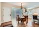 Bright dining area with hardwood floors and a unique glass block wall feature adjacent to the kitchen at 5461 S Youngfield Ct, Littleton, CO 80127