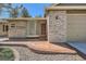 Exterior of a brick home featuring a unique glass block window and a covered front entrance at 5461 S Youngfield Ct, Littleton, CO 80127