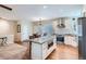 Open kitchen design with island, stainless appliances, granite countertops, and hardwood floors at 5461 S Youngfield Ct, Littleton, CO 80127
