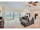 Spacious living room with plush carpeting, ceiling fan and glass sliding doors allowing natural light at 5461 S Youngfield Ct, Littleton, CO 80127