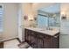 Well-lit main bathroom with dual sink vanity and an adjacent walk-in glass shower and glass block privacy window at 5461 S Youngfield Ct, Littleton, CO 80127