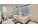 Elegant main bathroom featuring a soaking tub, glass shower, and privacy window with glass block at 5461 S Youngfield Ct, Littleton, CO 80127