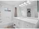 Bright bathroom with a shower and tub, white tile, and a vanity with a large mirror at 1716 W Sunset St, Longmont, CO 80501