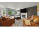 Comfortable living room with a fireplace, mounted television and cozy leather sofas at 1716 W Sunset St, Longmont, CO 80501