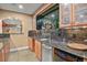 Basement bar with granite countertop, stainless steel sink, wooden cabinets, and mirrored backsplash at 670 Independence Dr, Larkspur, CO 80118
