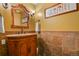 Bathroom showcasing a vanity with a wood cabinet, decorative mirror, and sconce lighting at 670 Independence Dr, Larkspur, CO 80118