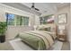 Bright bedroom featuring two windows, a ceiling fan, neutral walls, and stylish decor at 670 Independence Dr, Larkspur, CO 80118