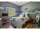 Comfortable bedroom with a window view, stylish desk, and mountain-themed wall art, creating a relaxing space at 670 Independence Dr, Larkspur, CO 80118