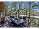 A peaceful outdoor deck with a dining table, surrounded by tall trees and nature at 670 Independence Dr, Larkspur, CO 80118