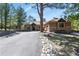 Exterior shot featuring a spacious driveway with well maintained lawn and lovely tree at 670 Independence Dr, Larkspur, CO 80118