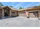 A beautiful two-car garage with stone accents and a pristine paved driveway at 670 Independence Dr, Larkspur, CO 80118
