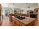 Spacious kitchen featuring a large island with cooktop, custom cabinetry and hardwood floors at 670 Independence Dr, Larkspur, CO 80118