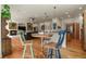 An open-concept living room featuring a dining table, a fireplace, and hardwood floors at 670 Independence Dr, Larkspur, CO 80118