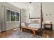 Serene main bedroom with a four-poster bed, large windows with natural light and hardwood floors at 670 Independence Dr, Larkspur, CO 80118