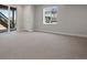 Spacious basement featuring neutral carpet, a window with a backyard view, and a walkout patio at 6881 Oak Canyon Cir, Castle Pines, CO 80108