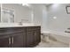 Bathroom features a dark vanity with a white countertop and backsplash, complemented by a shower-tub combo at 6881 Oak Canyon Cir, Castle Pines, CO 80108