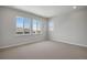 Well-lit bedroom with carpet, large windows, and neutral wall color at 6881 Oak Canyon Cir, Castle Pines, CO 80108