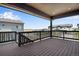 Relaxing covered deck showcasing dark wood flooring, black railing, and scenic neighborhood views at 6881 Oak Canyon Cir, Castle Pines, CO 80108
