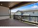 Spacious covered deck featuring wood flooring and black railing, with a neighborhood view at 6881 Oak Canyon Cir, Castle Pines, CO 80108