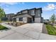 Modern townhome showcasing a gray exterior, private driveway, and well-maintained landscaping at 6881 Oak Canyon Cir, Castle Pines, CO 80108