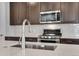 Features a close up of a kitchen with stainless steel appliances, dark cabinets, and white countertops at 6881 Oak Canyon Cir, Castle Pines, CO 80108