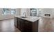 Features a kitchen island with stainless steel dishwasher and sink, with a living space in the background at 6881 Oak Canyon Cir, Castle Pines, CO 80108