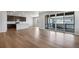 Spacious living room featuring hardwood floors, a kitchen, and sliding glass doors leading to an outdoor deck at 6881 Oak Canyon Cir, Castle Pines, CO 80108