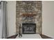 Stone fireplace featuring a wooden mantel, black metal fireplace doors, and decorative fireplace tools at 218 Wright St # 303, Lakewood, CO 80228