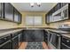 This is a galley kitchen with dark cabinets, modern appliances, and a window over the sink at 218 Wright St # 303, Lakewood, CO 80228