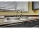 Close up of the kitchen sink and faucet, featuring dark cabinets and a window at 218 Wright St # 303, Lakewood, CO 80228