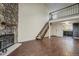 Open-concept living room with hardwood floors, a stone fireplace, staircase to a loft, and an adjacent kitchen at 218 Wright St # 303, Lakewood, CO 80228