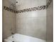 Shower tiled with beige tiles and mosaic design at 218 Wright St # 303, Lakewood, CO 80228