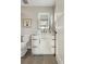 Bathroom with white vanity, toilet, and a lighted mirror at 2664 S Cherokee St, Denver, CO 80223