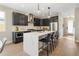 Modern kitchen with dark cabinetry, quartz island, and stainless steel appliances at 2664 S Cherokee St, Denver, CO 80223