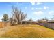 Spacious backyard with healthy lawn, mature tree, and perimeter wooden fence at 8235 Auburn Ln, Westminster, CO 80031