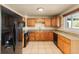 Eat-in kitchen features tile floors, wooden cabinets, stone countertops and black appliances at 8235 Auburn Ln, Westminster, CO 80031