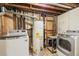 Functional laundry area featuring modern washer and dryer units, water heater, and exposed ductwork at 8235 Auburn Ln, Westminster, CO 80031