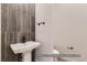 Elegant powder room with pedestal sink and dark tile at 9719 Canyon Wind Pt, Parker, CO 80138