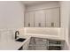 Modern wet bar with quartz countertops and sink at 9719 Canyon Wind Pt, Parker, CO 80138