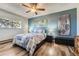 Charming bedroom with ceiling fan, natural light, and beautiful wood-look flooring at 15531 E Jewell Pl, Aurora, CO 80013