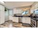 Bright kitchen with stainless steel appliances, black counters, and attractive laminate flooring at 15531 E Jewell Pl, Aurora, CO 80013