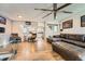 Open-concept living room with hardwood floors, modern furnishings, and a large fan at 15531 E Jewell Pl, Aurora, CO 80013