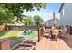 Inviting backyard featuring a wooden deck with dining set, outdoor seating area with a fire pit, and fenced yard at 8977 W Toller Ave, Littleton, CO 80128
