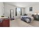 Bright bedroom with a large window, full-length mirror, and soft neutral carpet at 8977 W Toller Ave, Littleton, CO 80128