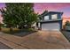 Charming two-story home featuring a two-car garage, lush front yard, and beautiful twilight sky at 8977 W Toller Ave, Littleton, CO 80128