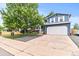 Charming two-story home with a well-manicured lawn, mature trees, and an attached two-car garage at 8977 W Toller Ave, Littleton, CO 80128