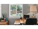 Comfortable office features a computer desk, chair, lamp, and view to the outside at 8977 W Toller Ave, Littleton, CO 80128