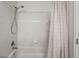 Bright white bathroom featuring tiled shower/tub combo and contemporary shower curtain at 12063 Monaco Ct, Brighton, CO 80602