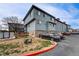 Blue townhome complex featuring convenient parking and well-maintained grounds at 12063 Monaco Ct, Brighton, CO 80602